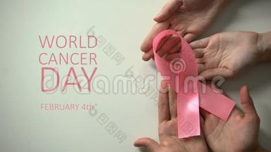 2月4日世界癌症日题字，人们手里拿着粉红色的丝带